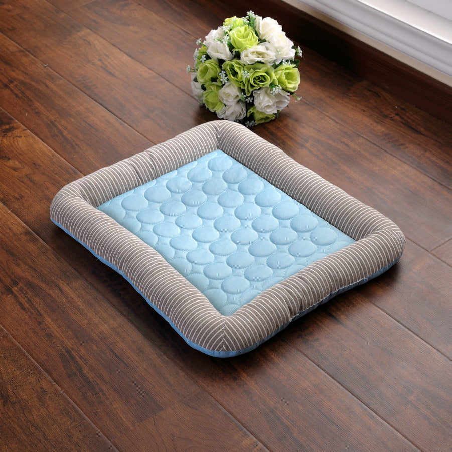 Pet cooling bed with gray striped border on a wooden floor 