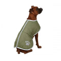 Dog wearing a green coat with a paw print
