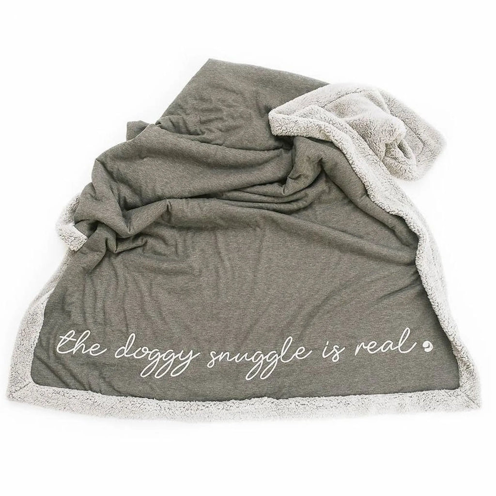 Gray blanket with white text 'the doggy snuggle is real'