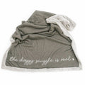 Gray blanket with white text 'the doggy snuggle is real'