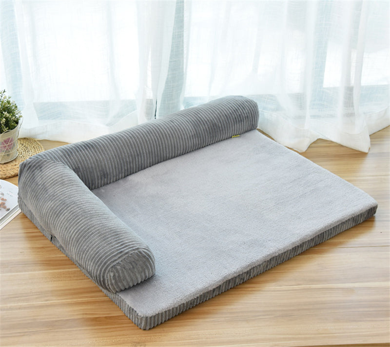Gray corduroy pet bed with cushions on 2 sides on a wooden floor 