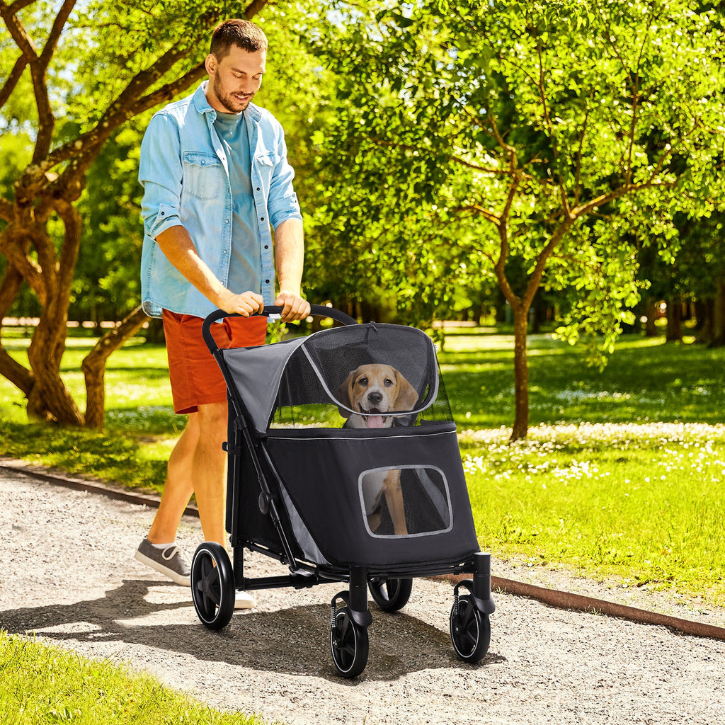Man pushing a pet stroller with a dog in a park